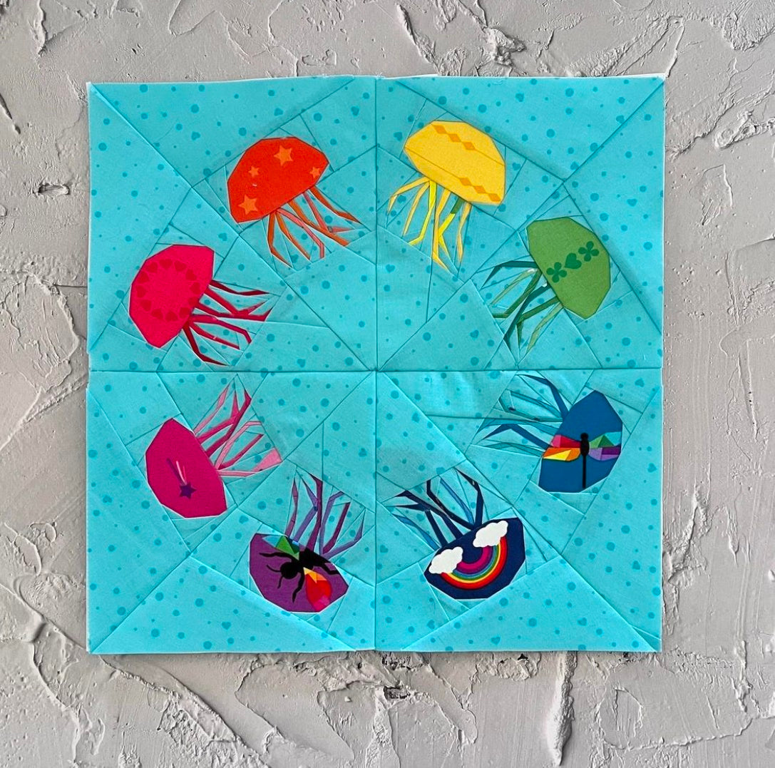 bloom of jellyfish paper pieced pattern sewn in rainbow fabric