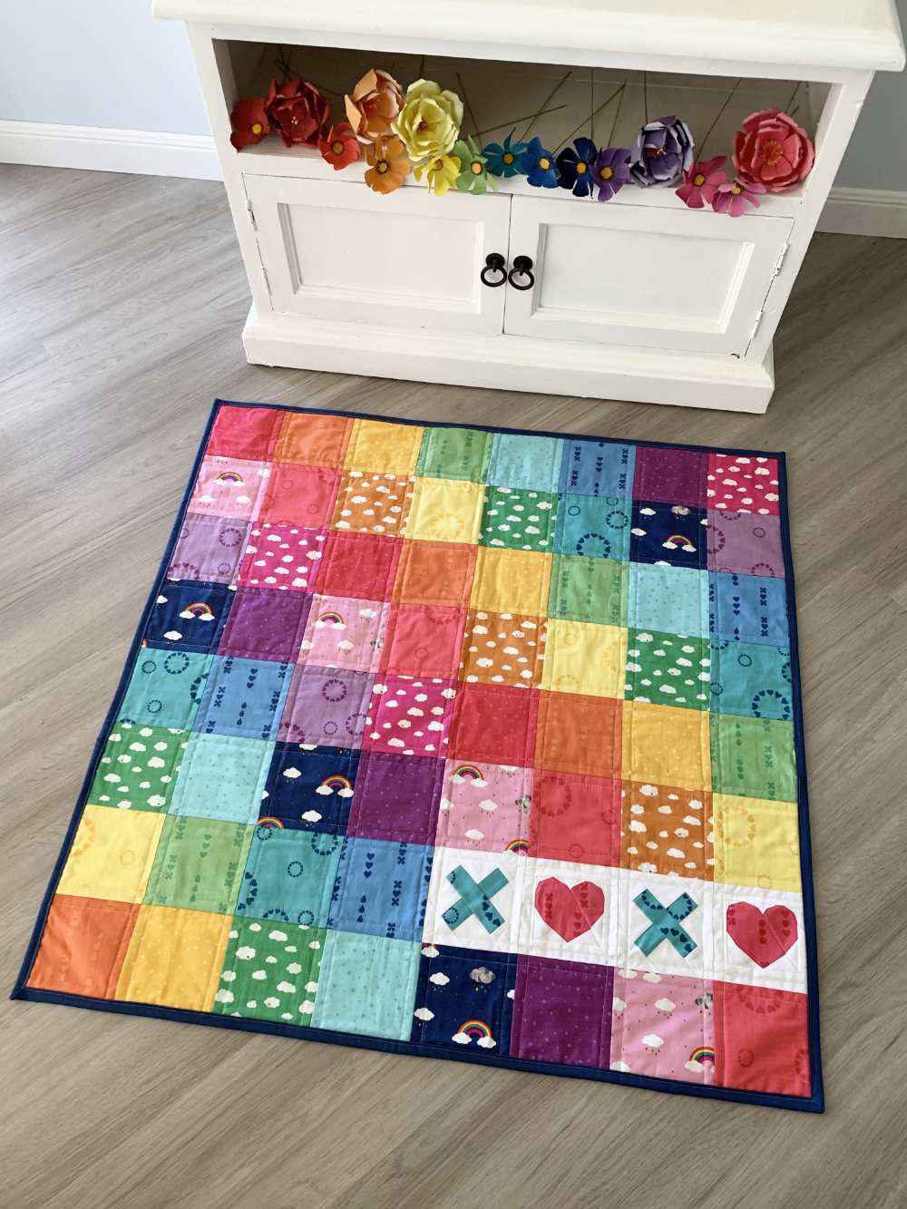 XOXO paper pieced quilt pattern in rainbow sewn in bright fabrics
