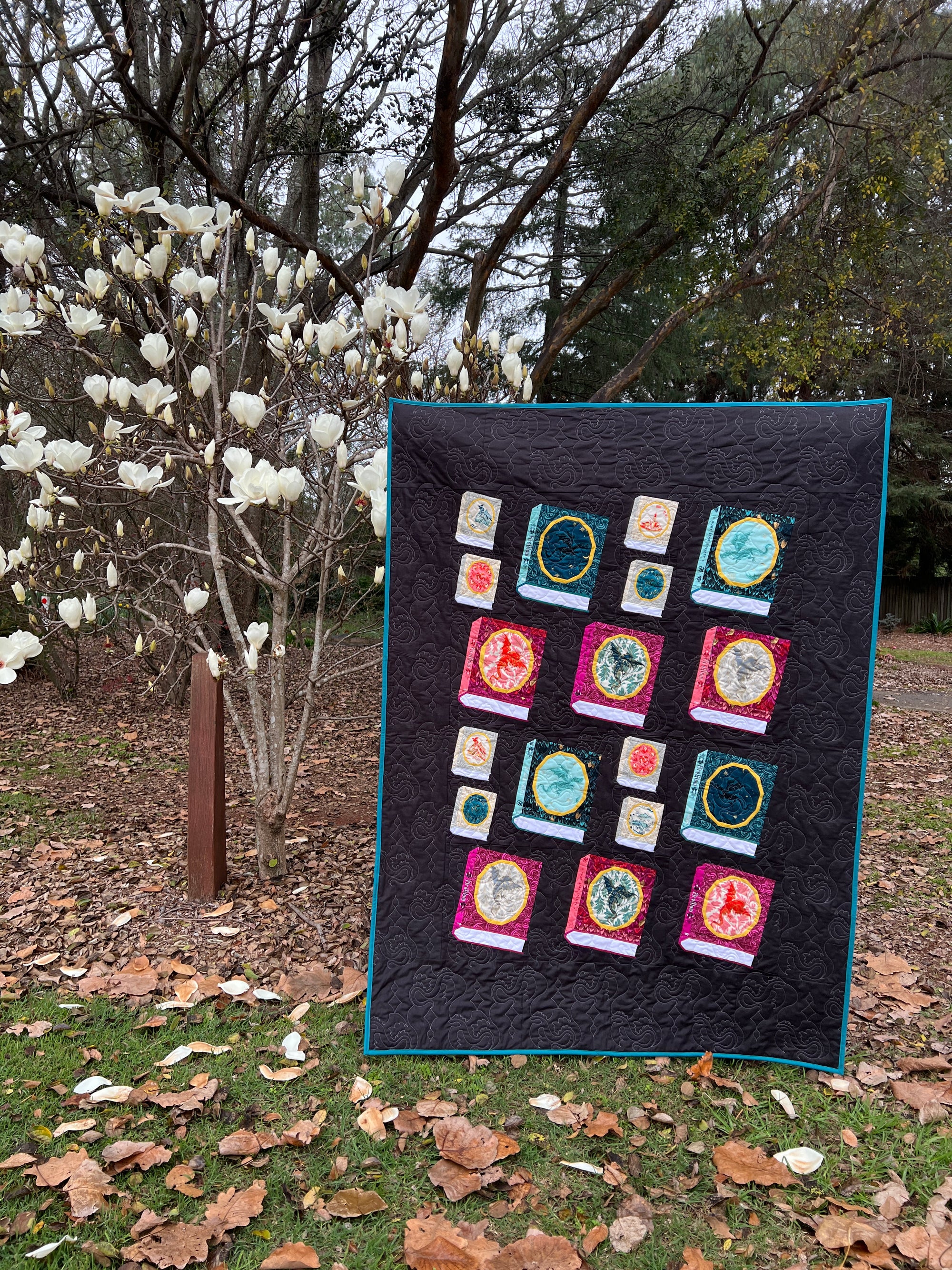 A quilt made with foundation paper pieced Book blocks featuring an oval frame for a fussycut fabric feature