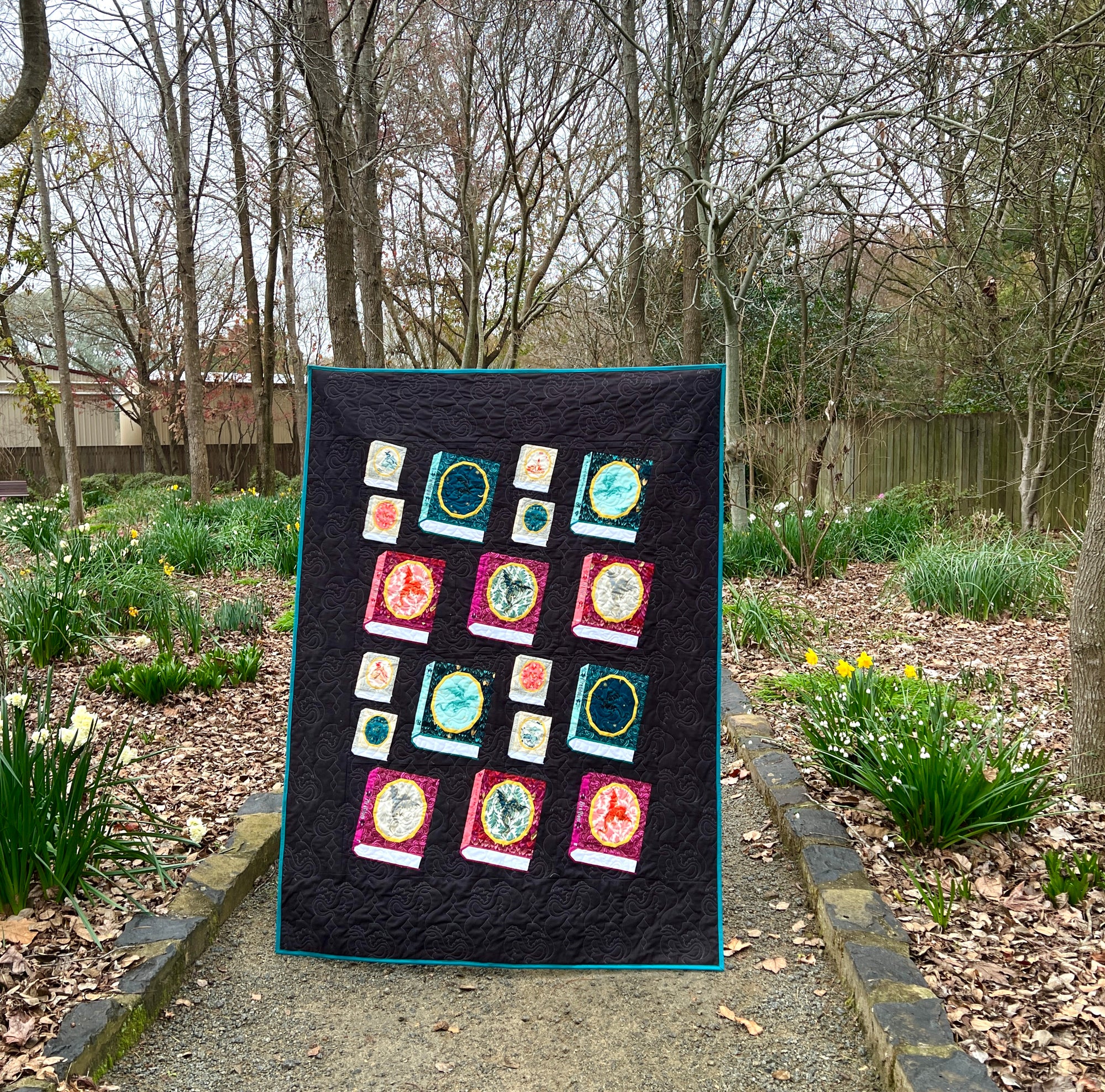 A quilt made with foundation paper pieced Book blocks featuring an oval frame for a fussycut fabric feature