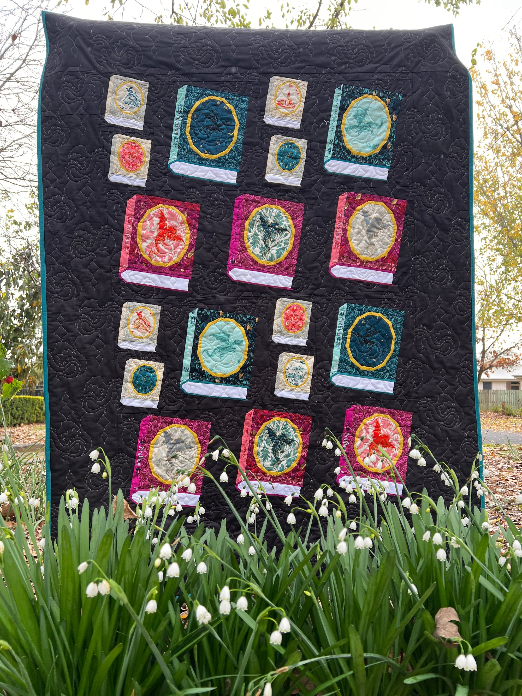 A quilt made with foundation paper pieced Book blocks featuring an oval frame for a fussycut fabric feature