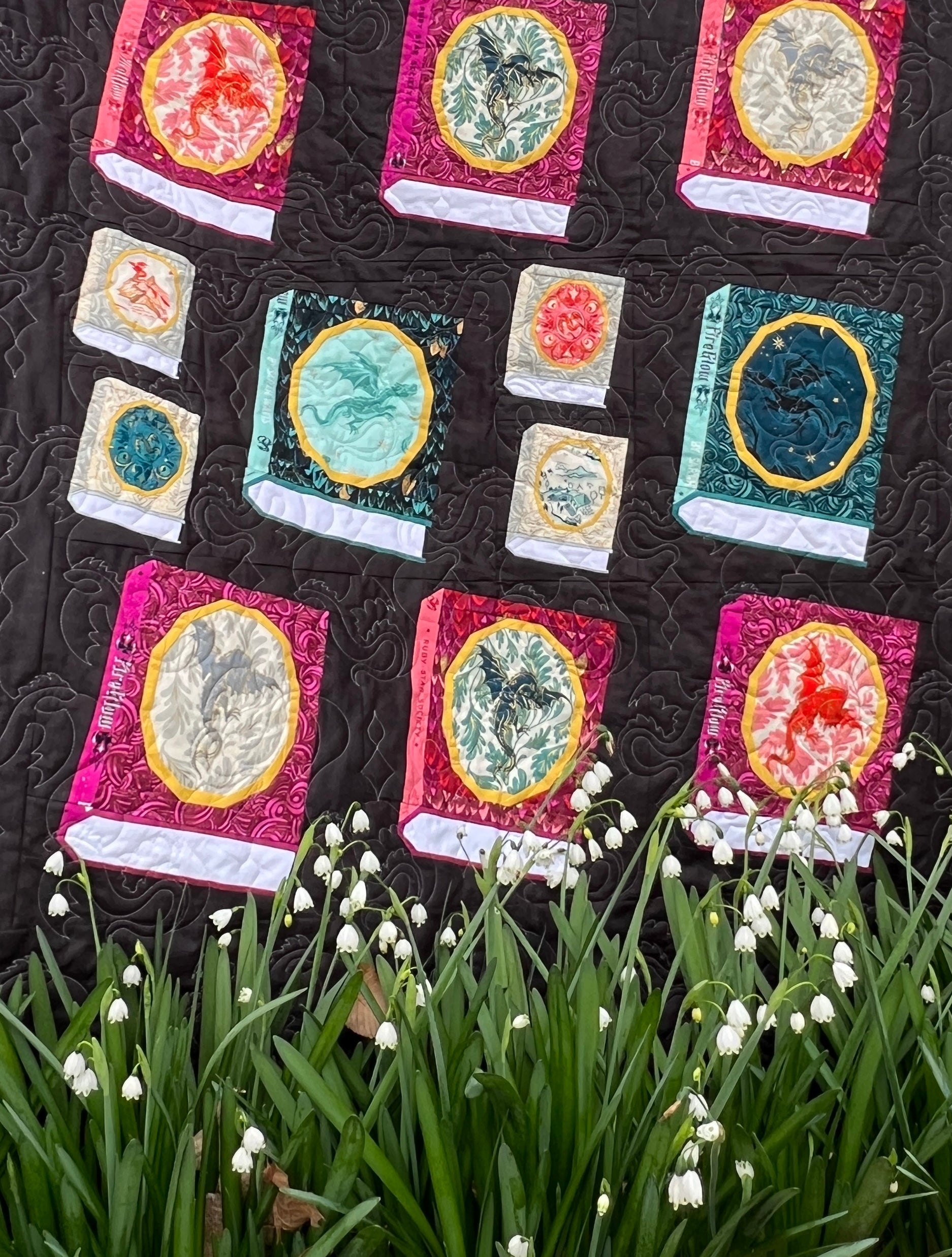 A quilt made with foundation paper pieced Book blocks featuring an oval frame for a fussycut fabric feature