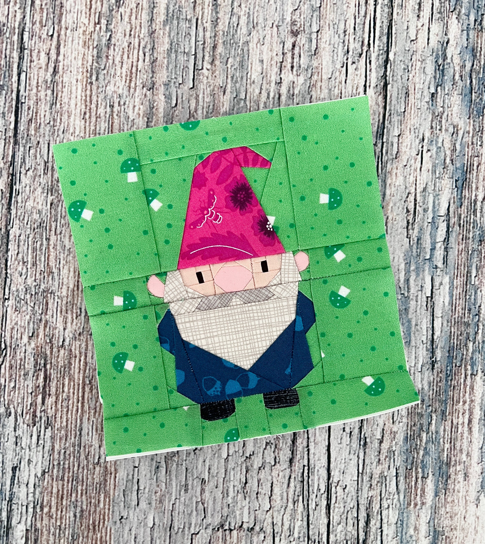 Foundation paper pieced garden gnome quilt block shown in a finished fabric sample. A fun and character-filled FPP design ideal for adding personality to quilts and seasonal sewing projects.