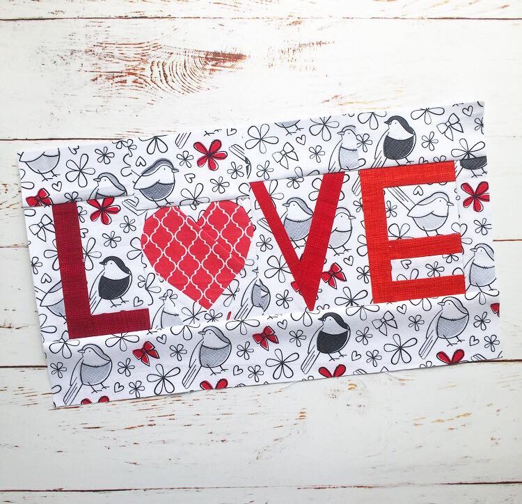 Love text paper pieced pattern with a heart sewn in fabric