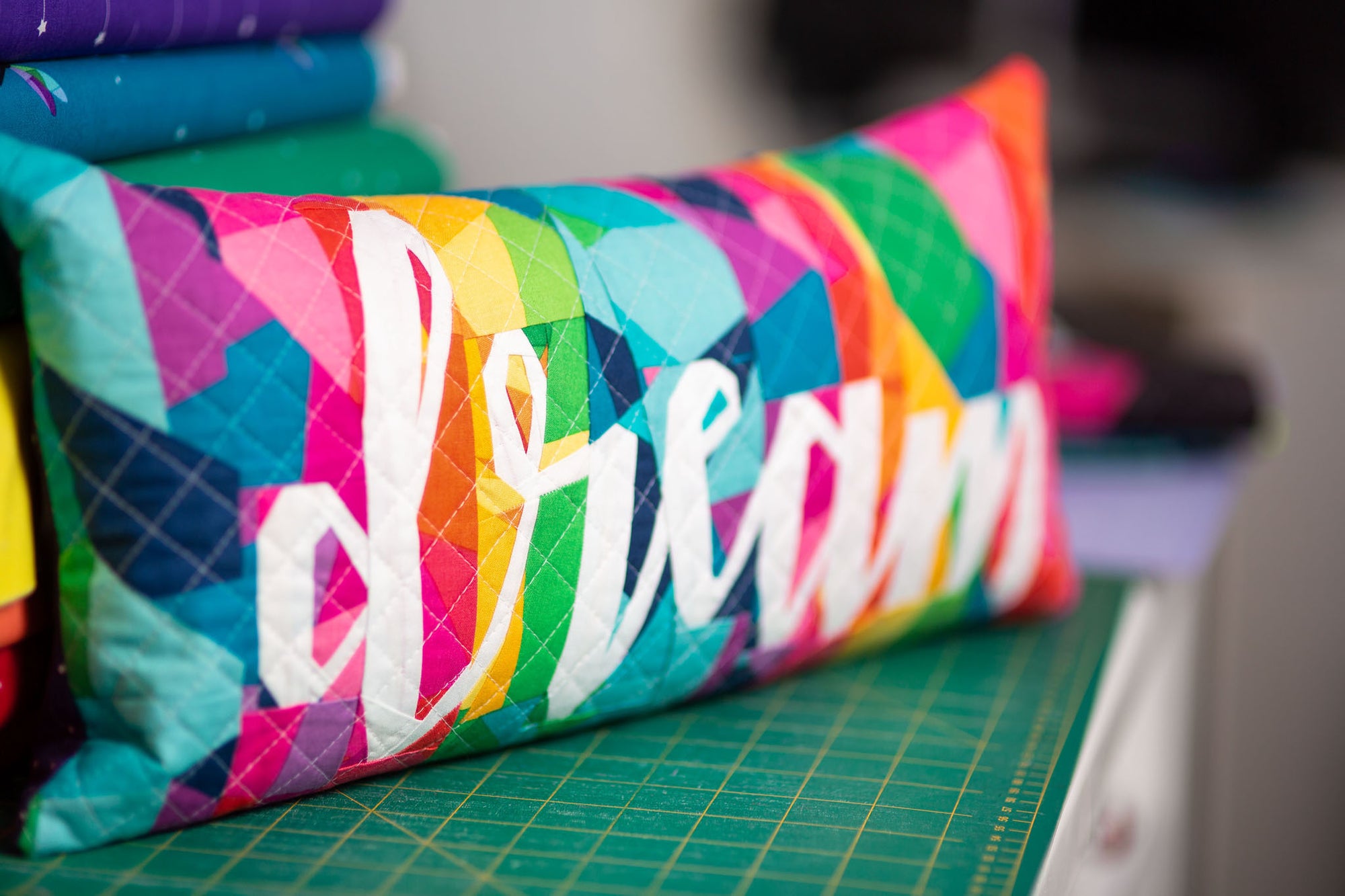 A rainbow geometric FPP cushion with the word "Dream"
