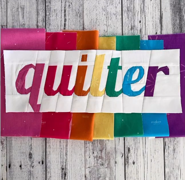 quilter in script paper pieced pattern sewn in rainbow fabric