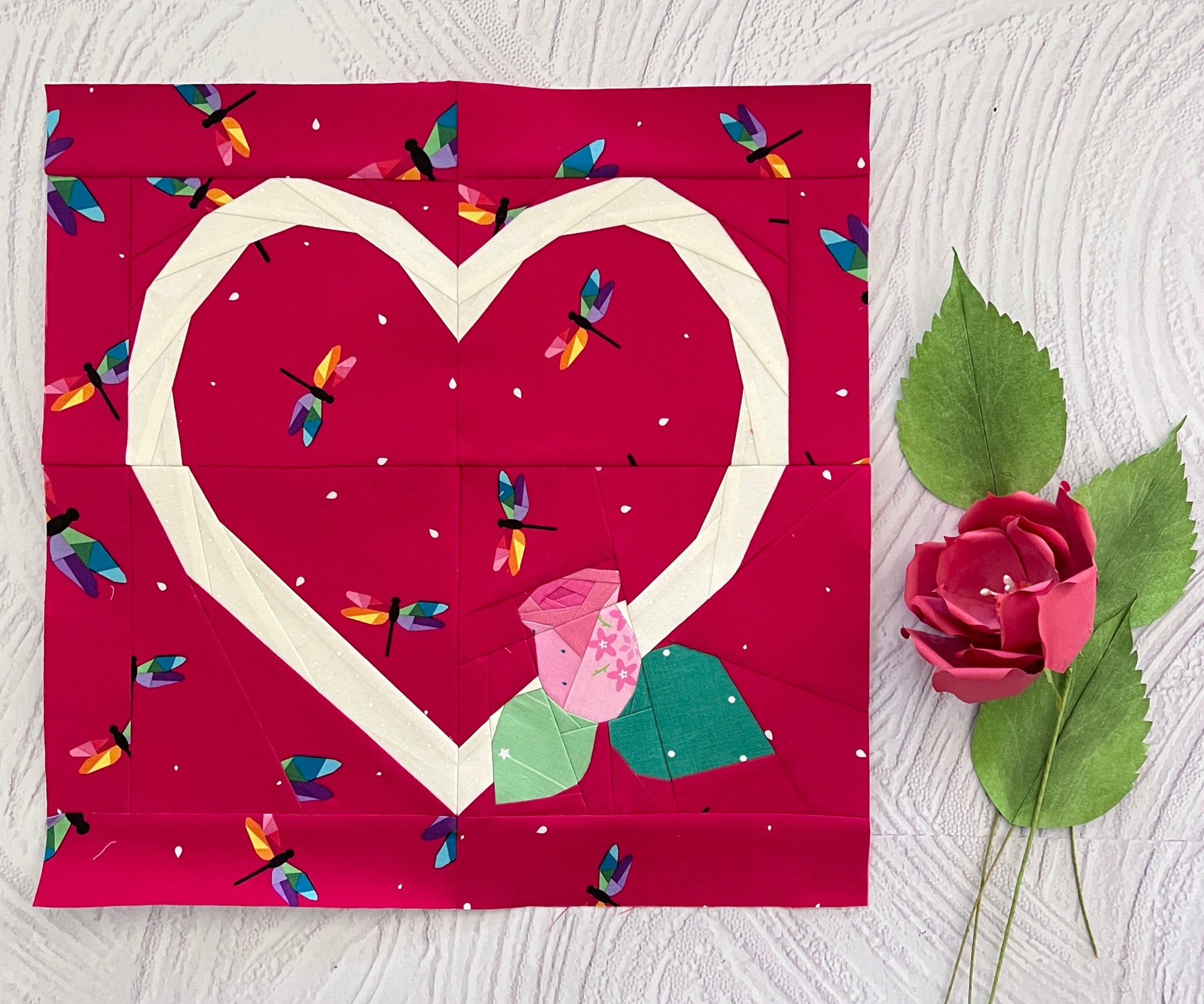 Finished foundation paper pieced heart quilt block shown in fabric with rose detail. A sweet and timeless FPP pattern that adds a romantic touch to quilts, cushions, and heartfelt handmade creations.