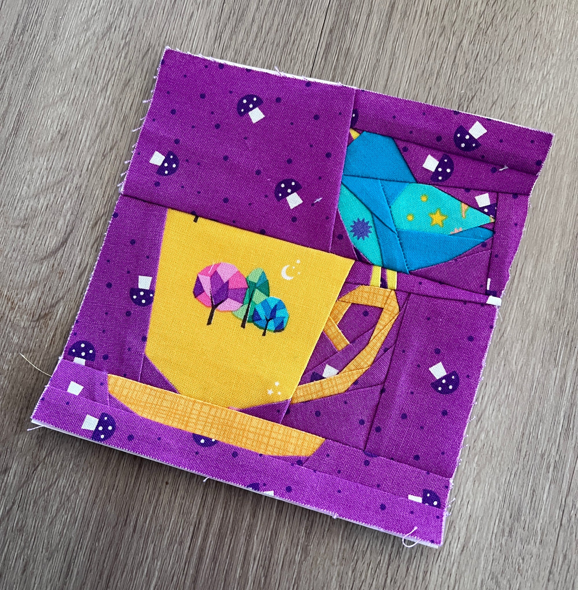 Foundation paper pieced bird and teacup quilt block shown in a finished fabric sample.