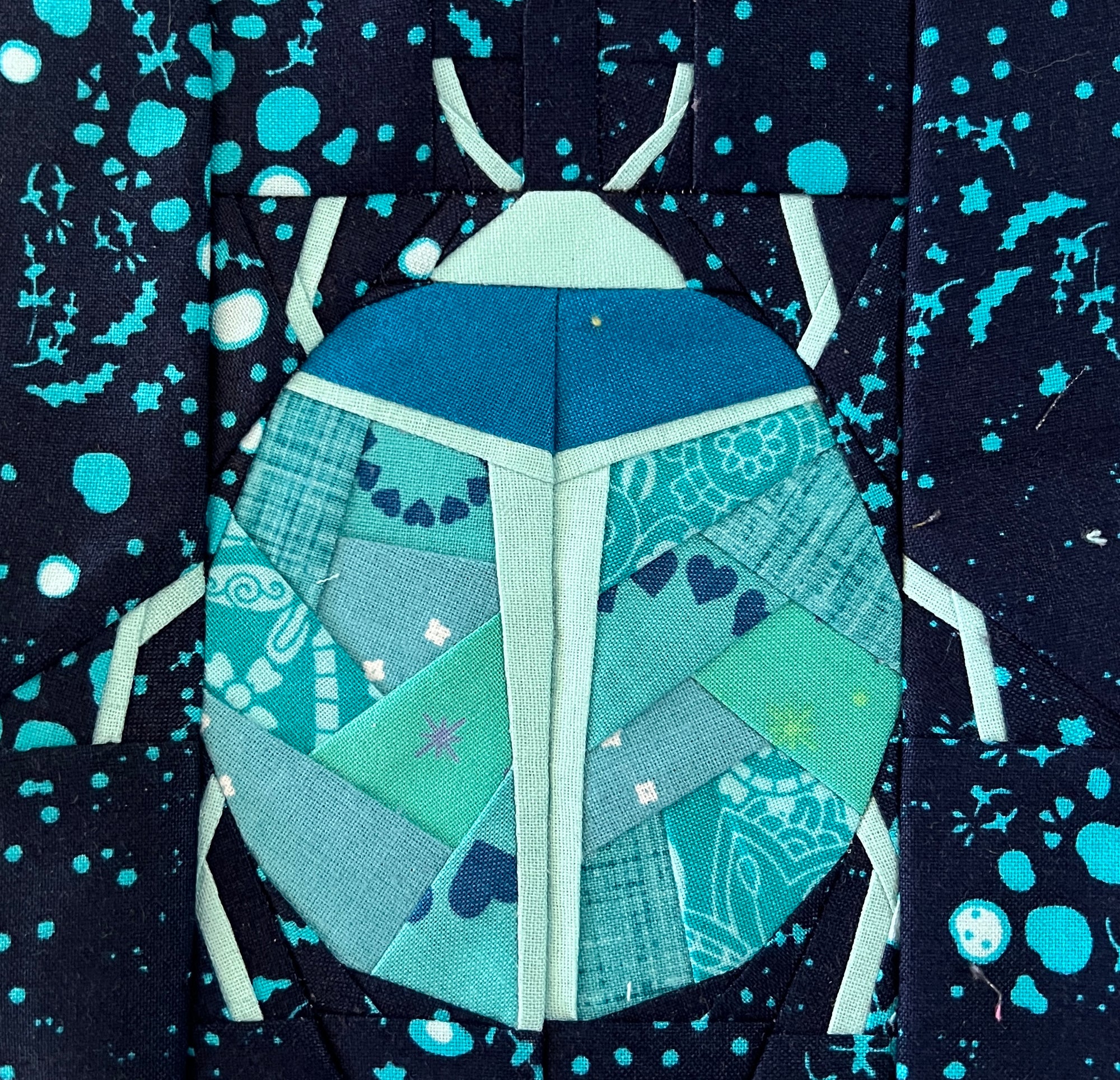 Geometric beetle bug foundation paper pieced quilt block sewn in teal fabric