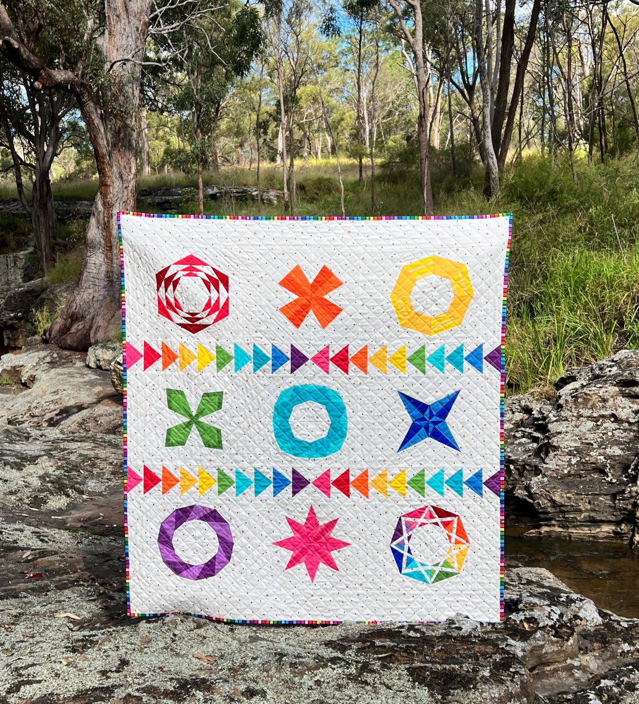 A quilt sewed from bright geometric foundation piece designs