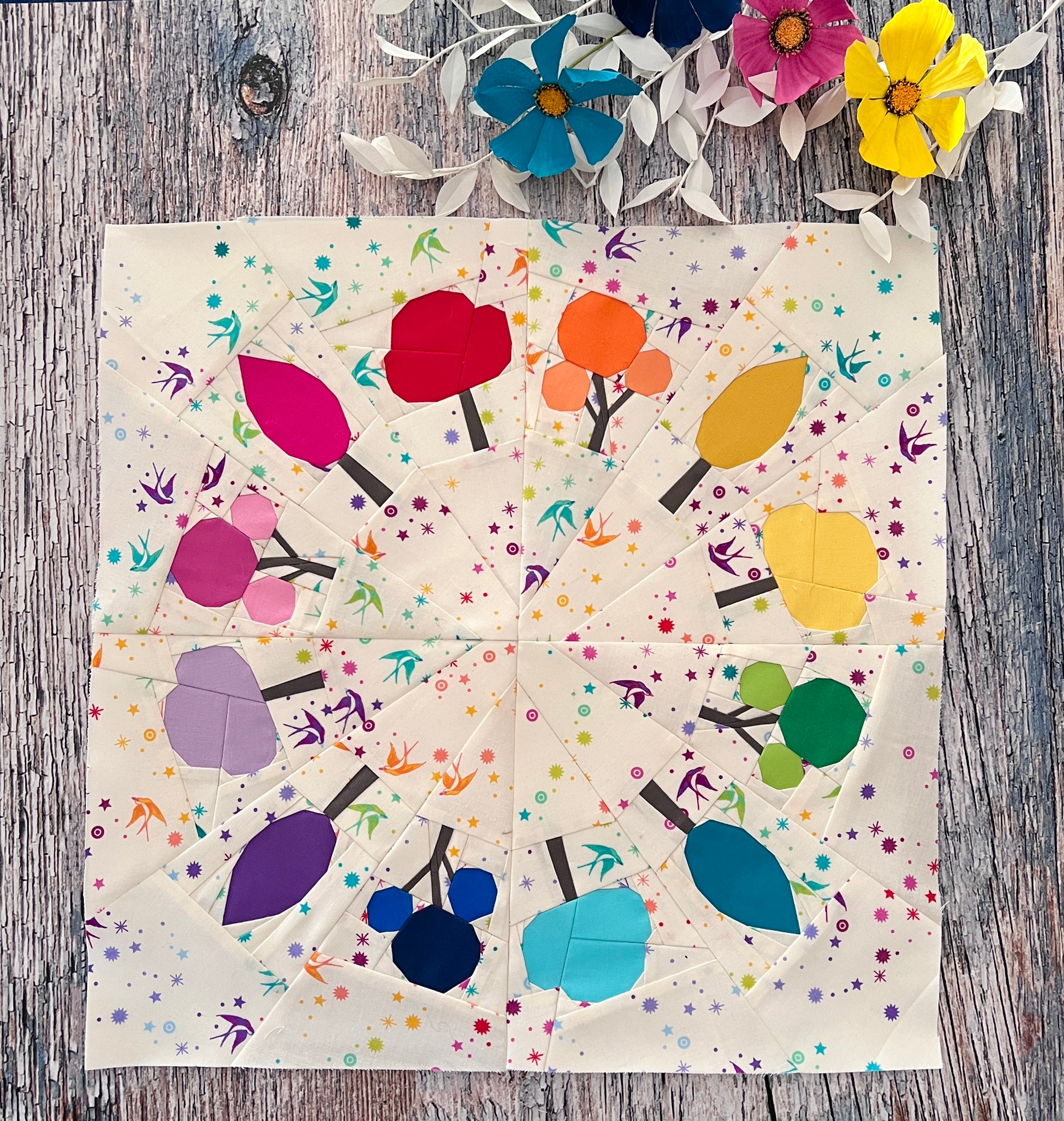 foundation-paper-piece-forest-trees-in-rainbow-colors-in-circle-on-rustic-background-completed-pattern