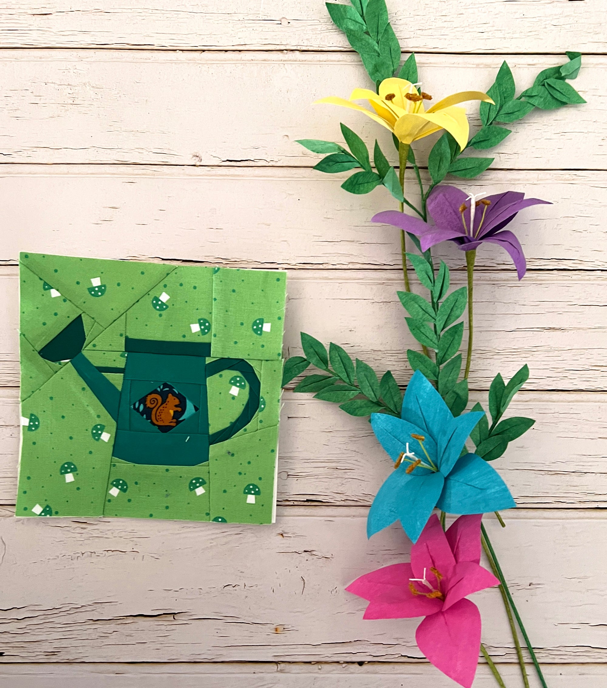 inished little watering can quilt block styled with flowers