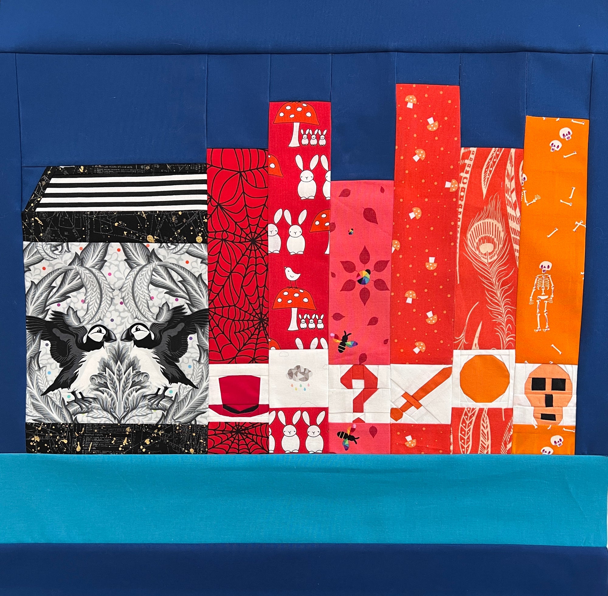 Alternate colourway bookshelf quilt created with The Library foundation paper pieced quilting pattern featuring bold red and orange fabrics